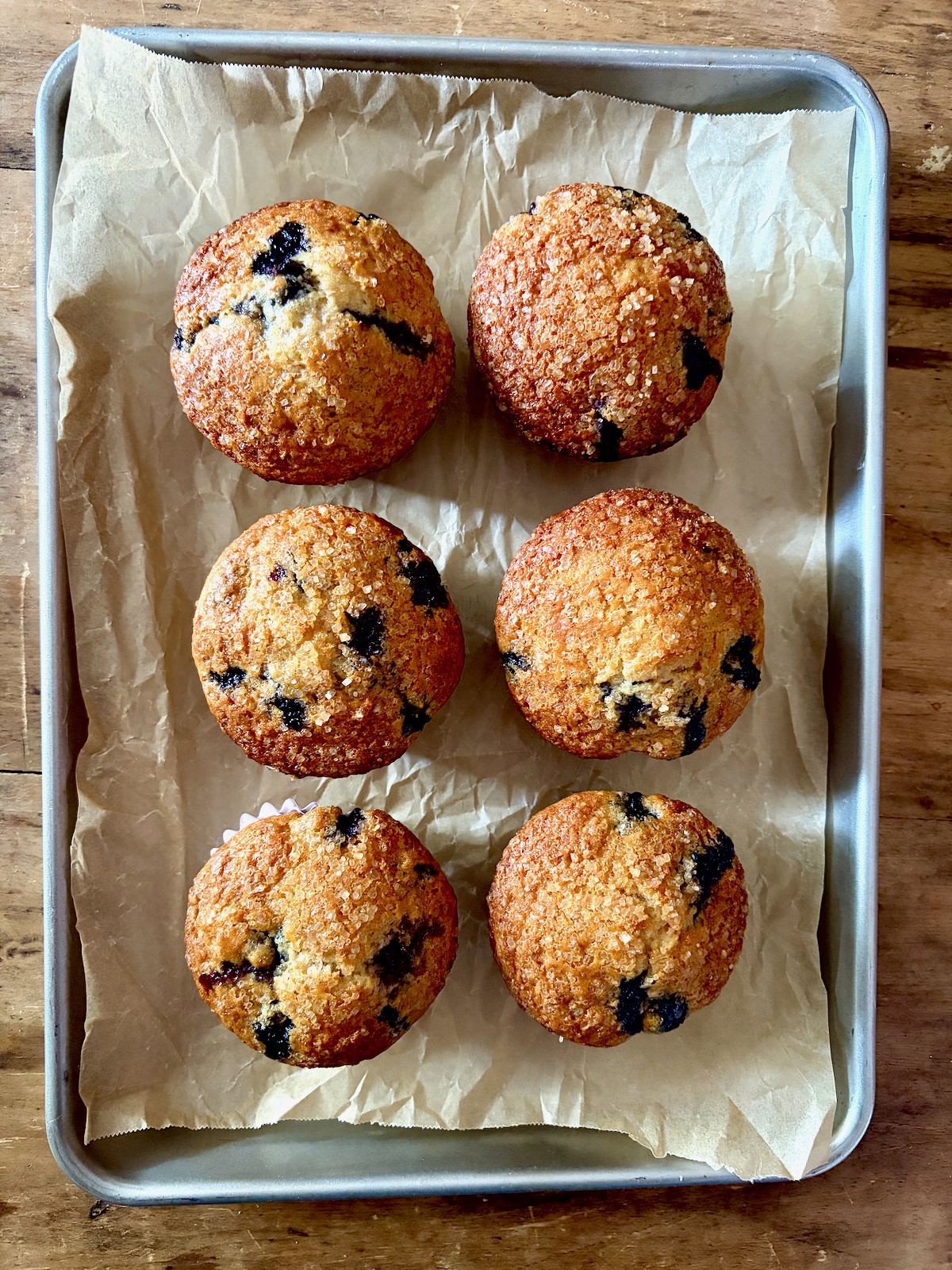 Dorie Greenspan's Bran Berry Muffins on a baking tray covered with parchment paper.